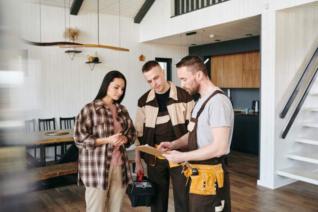 Young plumber in uniform giving document to female for her signature